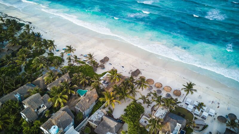 Traveler relaxing on a beach chair in Cancún with Southwest Airlines jet visible in the sky.