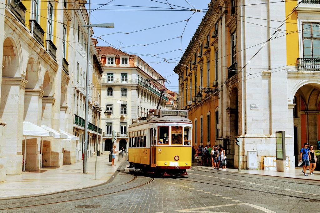 Yellow Tram 28 travelling through Alfama streets in Lisbon